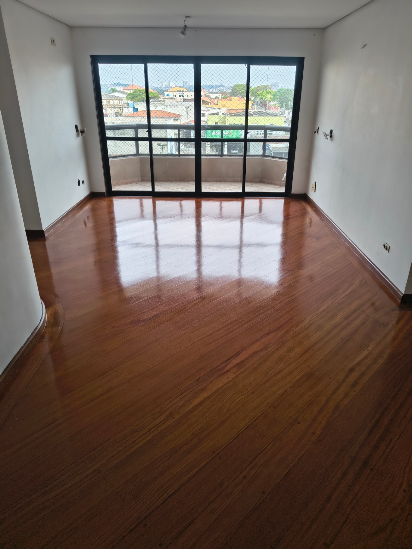 Assoalho de madeira vitrificado com alto brilho em sala de apartamento