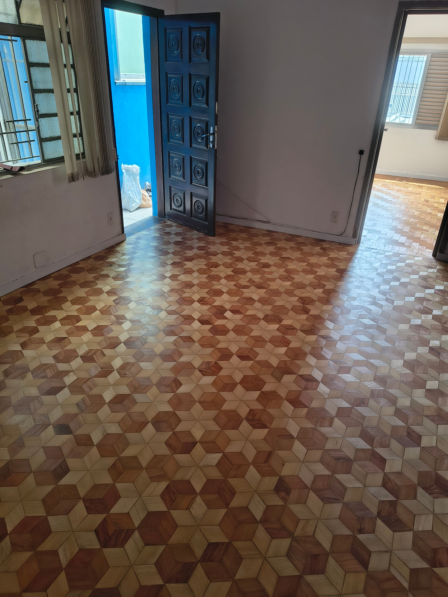 Piso de madeira com desenho geométrico restaurado em sala