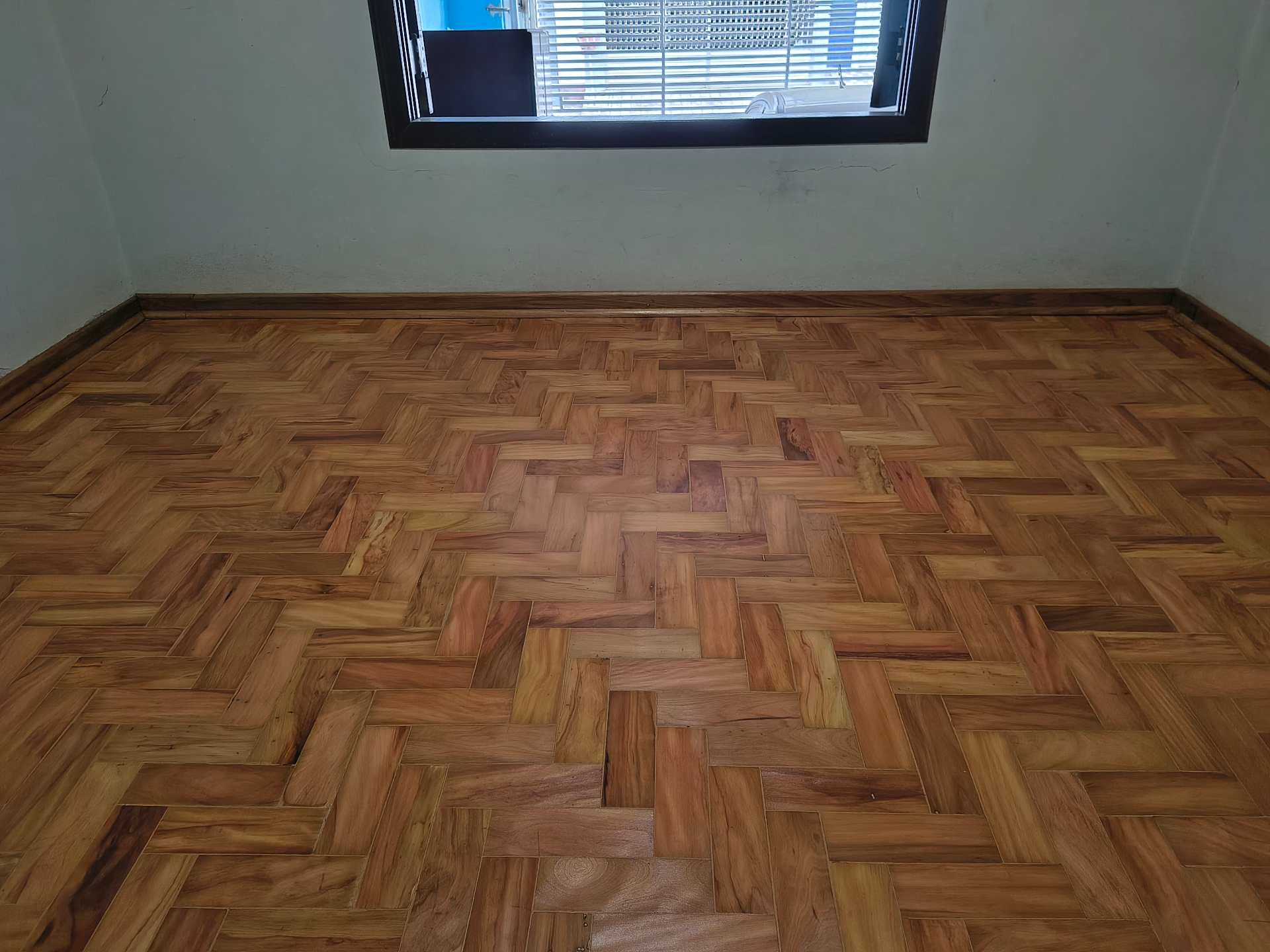 Quarto com piso de taco nivelado e acabamento acetinado