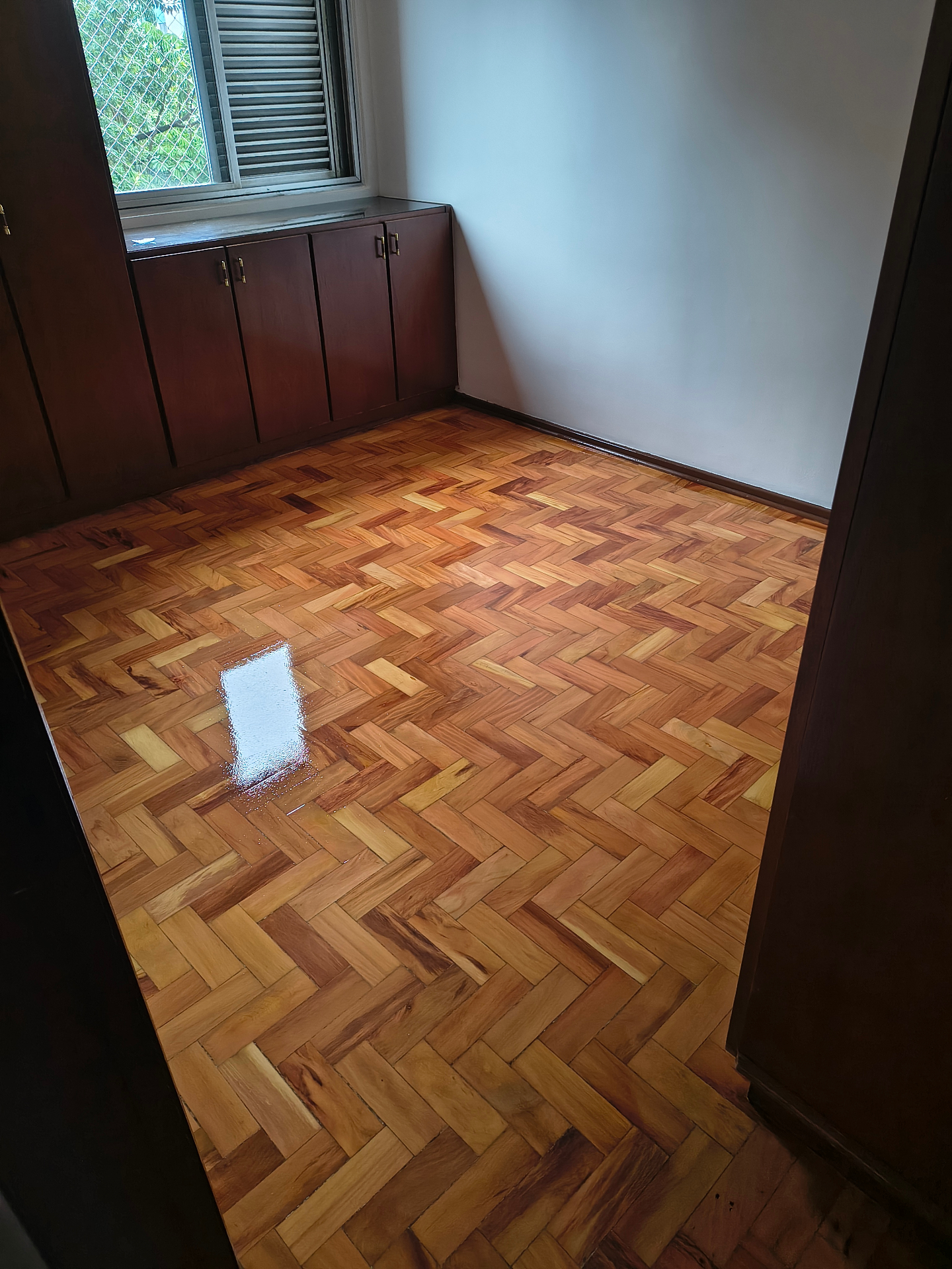 Piso de tacos restaurado com acabamento brilhante em quarto
